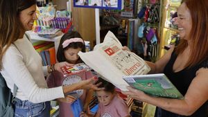 Una familia recoge sus libros de texto en la librería Cativos.