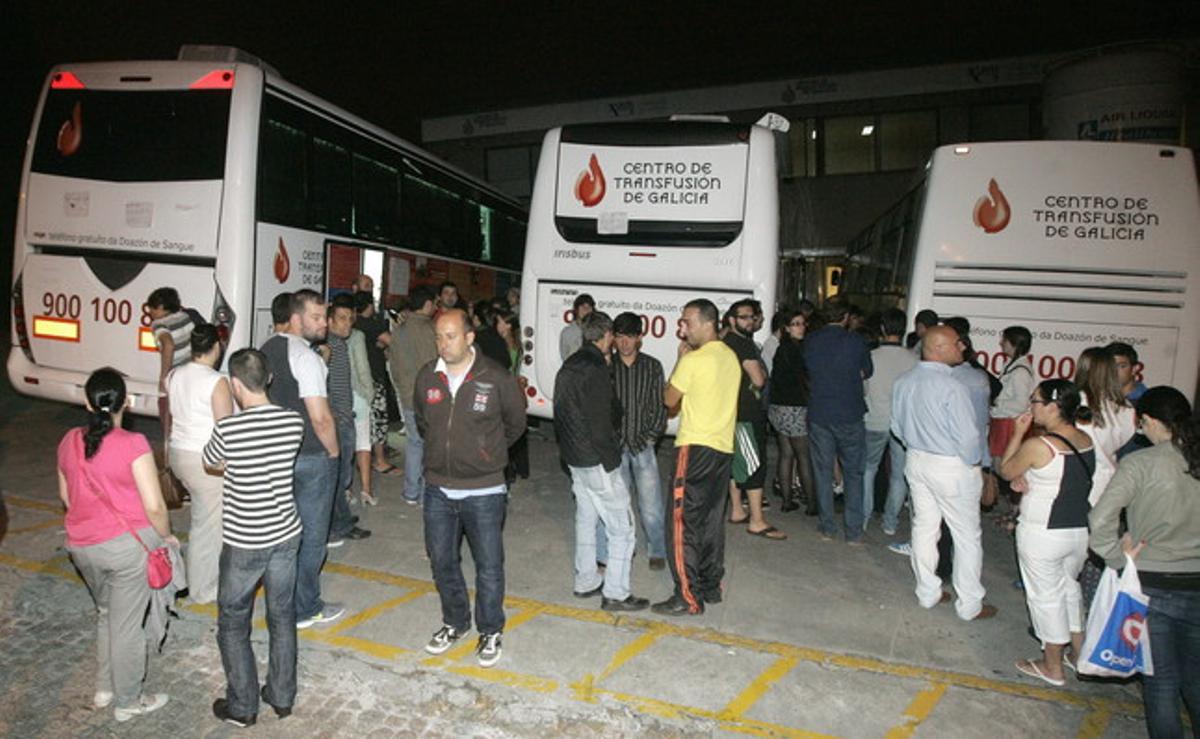 Ciutadans fan cua davant vehicles de la Creu Roja per donar sang per als ferits en l’accident de Santiago, ahir a la nit.