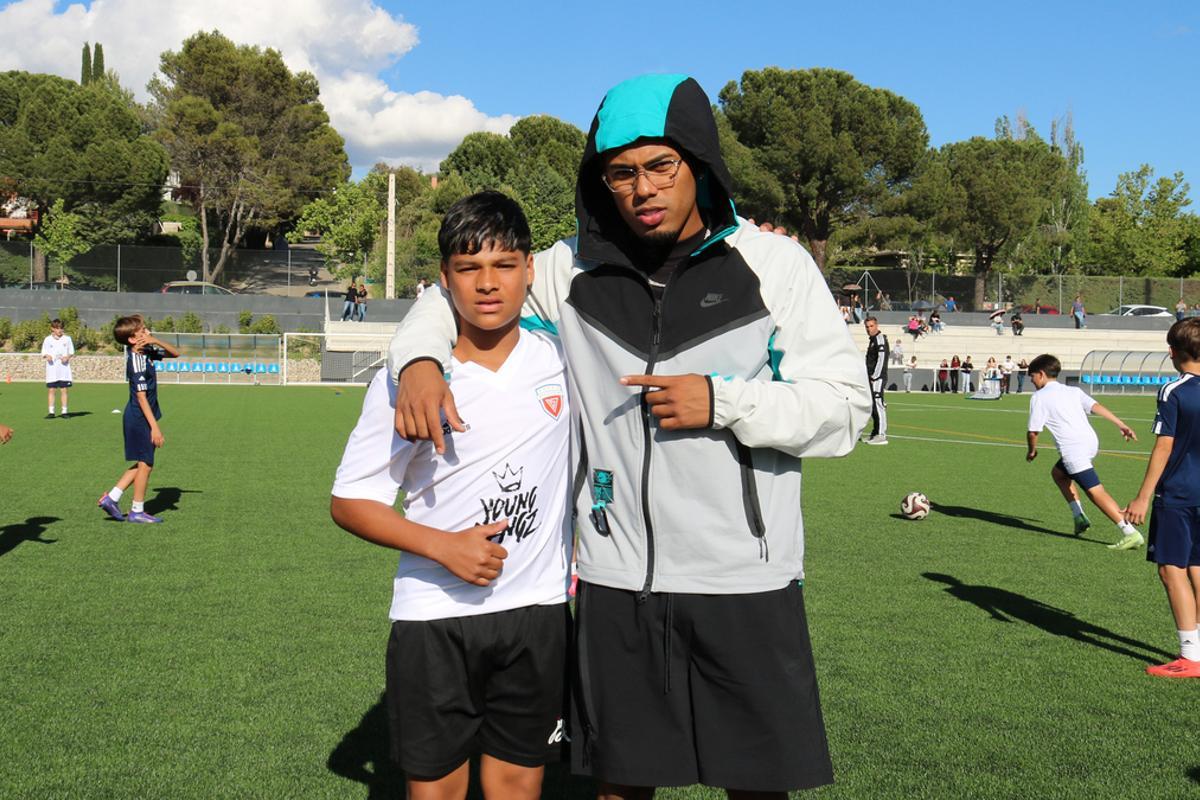 Myke Towers, posing with one of the academy's kids