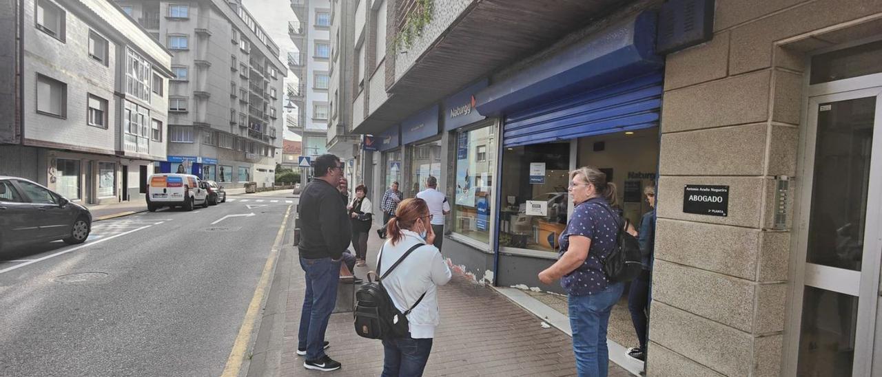 Clientes esperando en la cola, ayer, ante la oficina de la rúa Baiona, en Cangas.   | // FDV