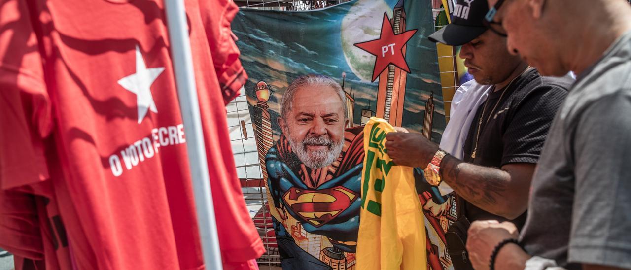 Un hombre compra en un puesto ambulante una camiseta de Lula da Silva.