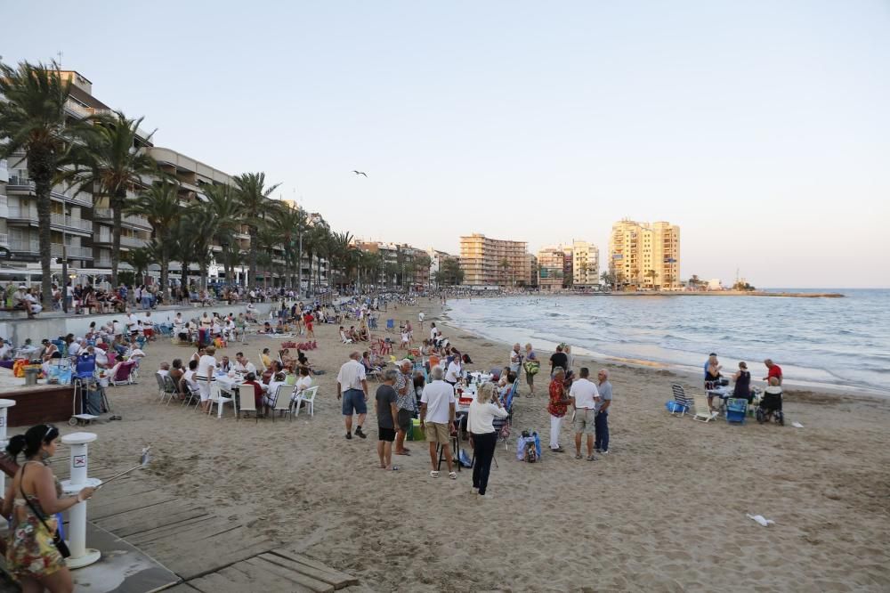 Noche de hogueras, baños, en las playas de la Vega Baja. En las imágenes grupos de amigos y familias en la playa del Cura de Torrevieja