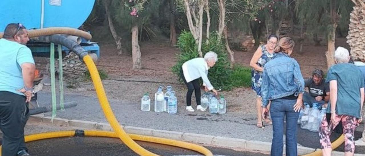 Una imagen actual de vecinos de la localidad turística de Costa Calma llenando agua en garrafas desde un camión-cisterna ante la falta de agua en sus domicilios.