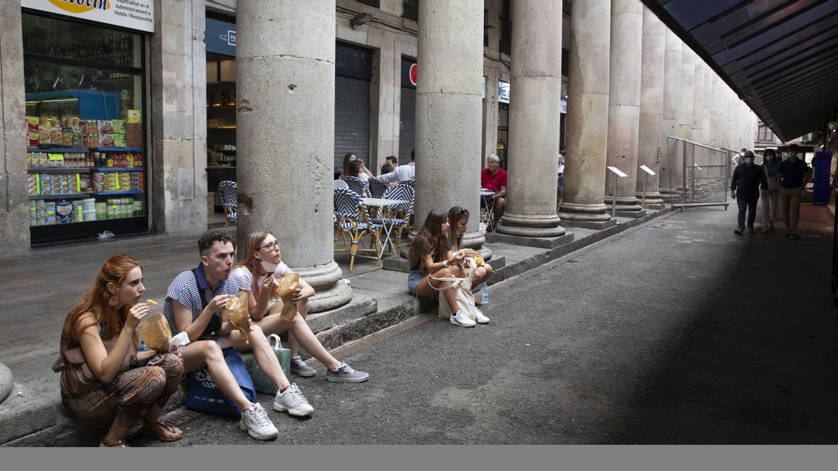 Gente joven degustando con sus tapitas compradas en el mercado