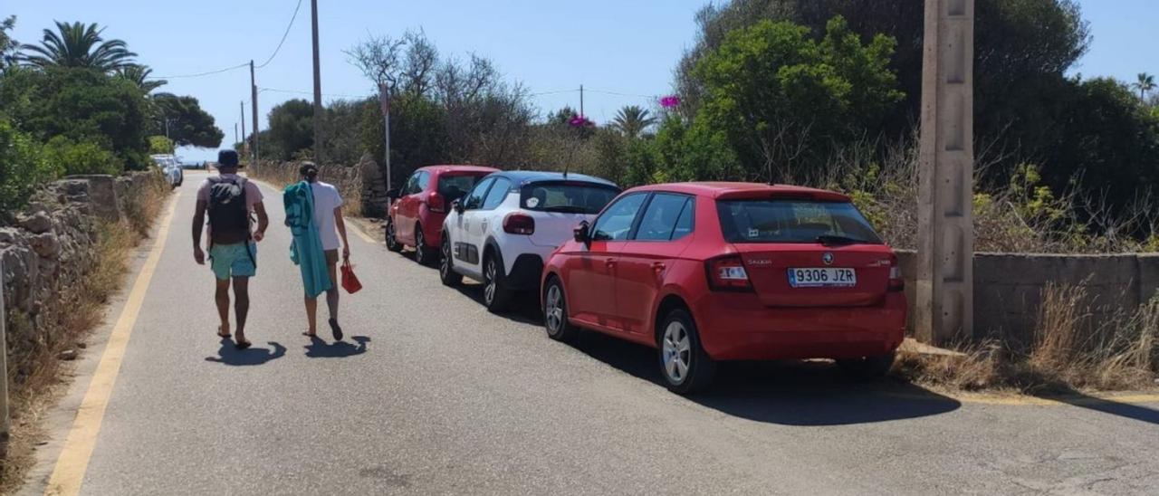 Dos bañistas se dirigen a buscar su coche en Cala Llombards.