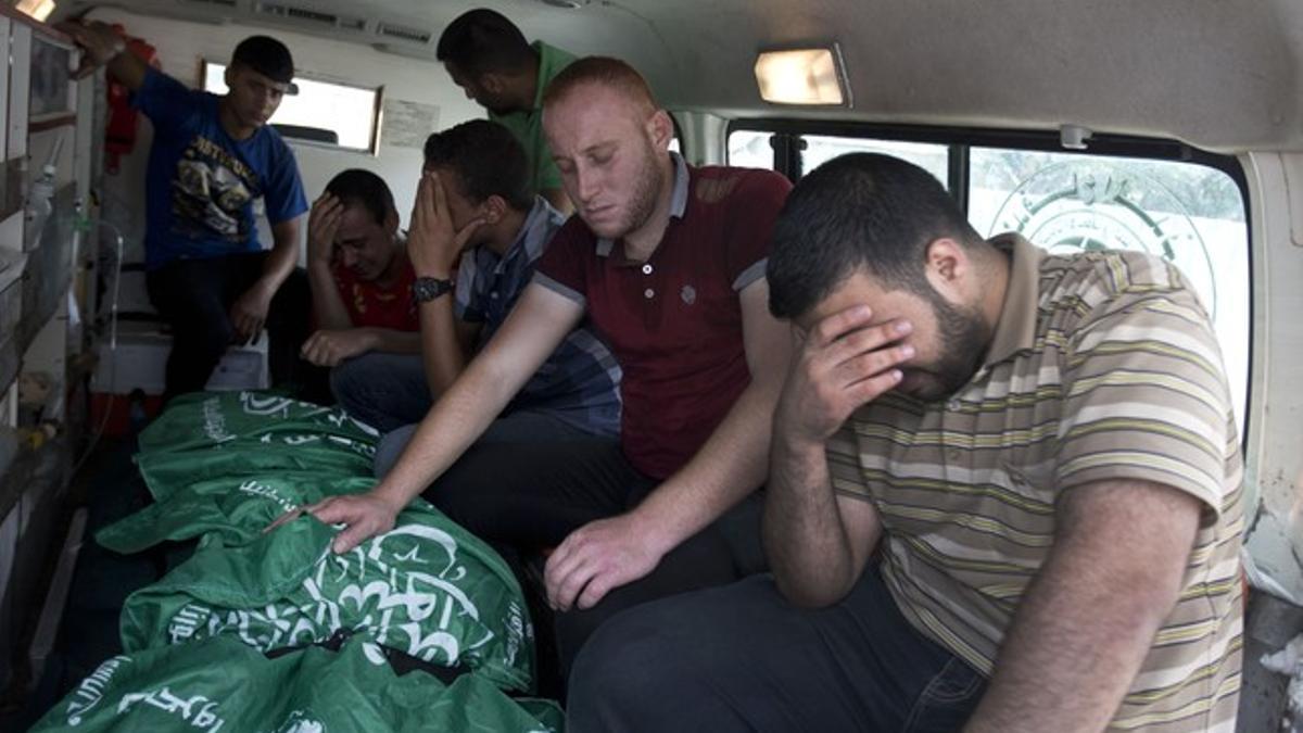Varios palestinos lloran junto a los cadáveres de familiares muertos durante los últimos ataques de Israel sobre Gaza.