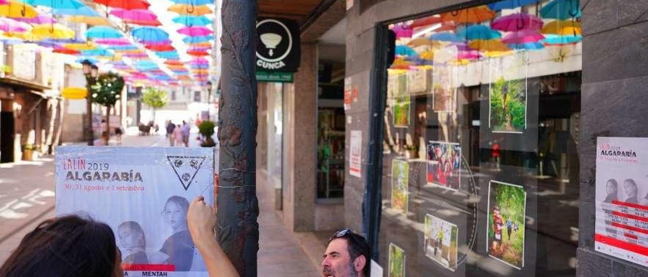 A organización coloca carteis da Algarabía na rúa Colón. // Bernabé