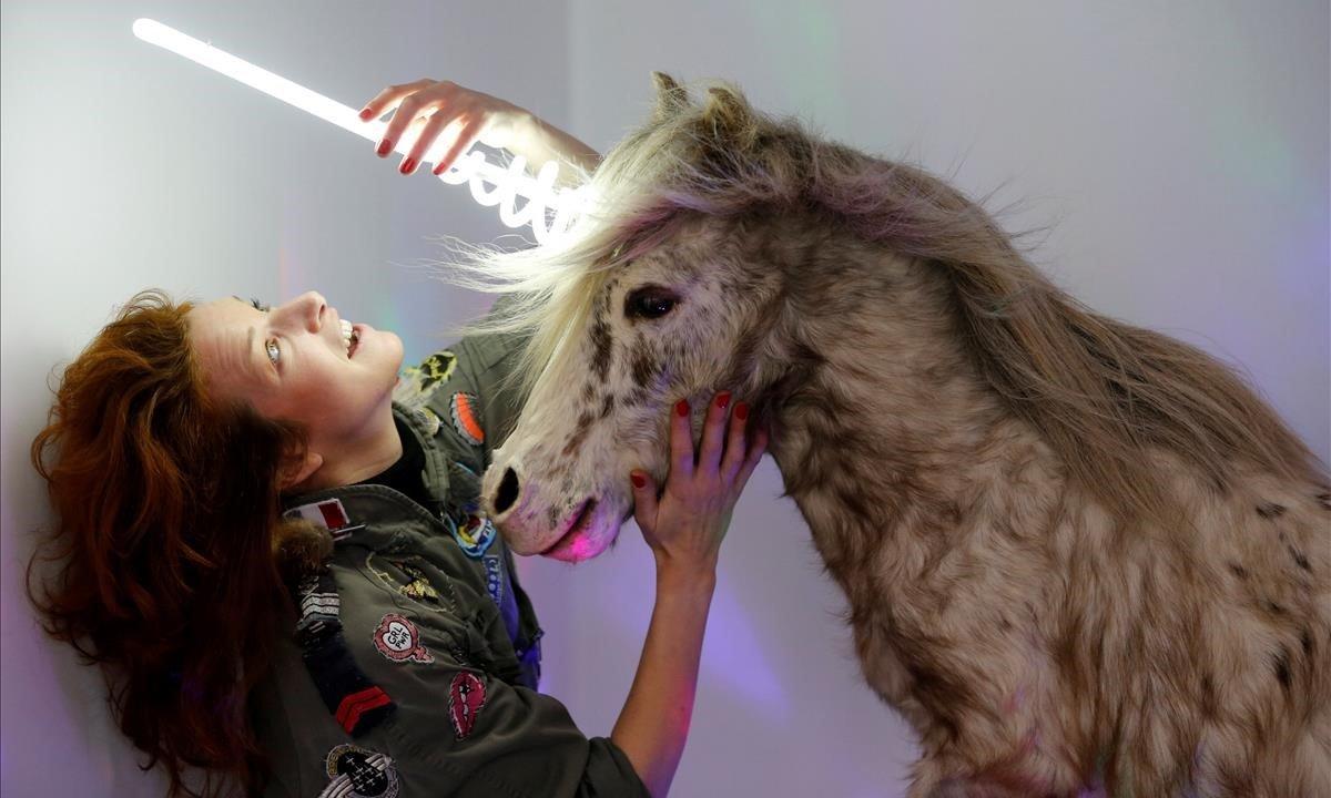 La artista y naturalista Stephanie Barthes ajusta una lámpara de neón en un pony de peluche mientras trabaja en su creación artística llamada Poney-Licorne en su taller en Burdeos, Francia.