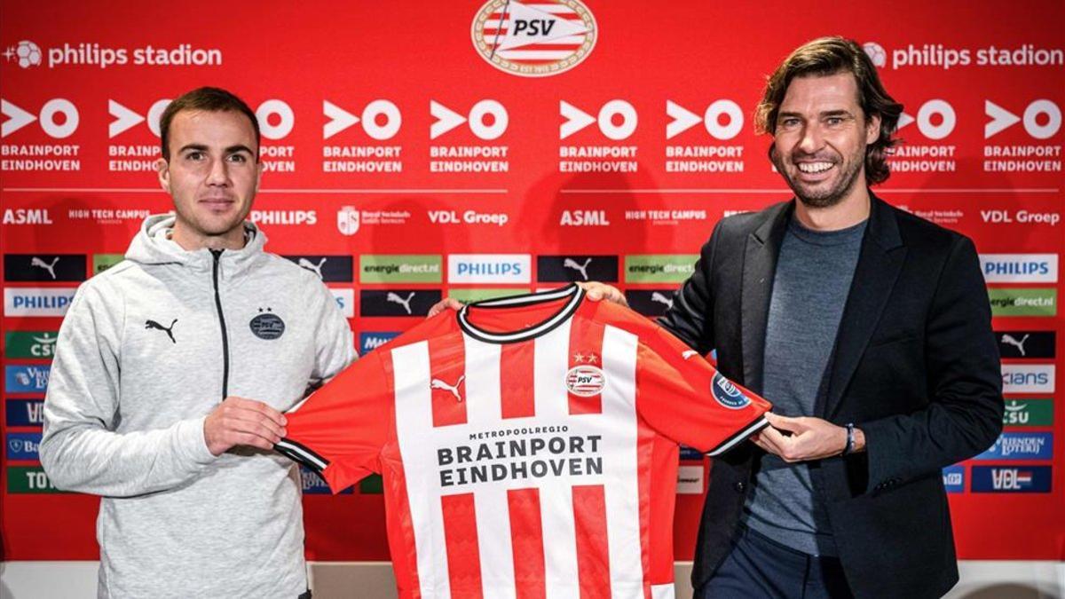 El mediocampista alemán del PSV Eindhoven Mario Götze y el director técnico holandés John de Jong sostienen la nueva camiseta de Götze