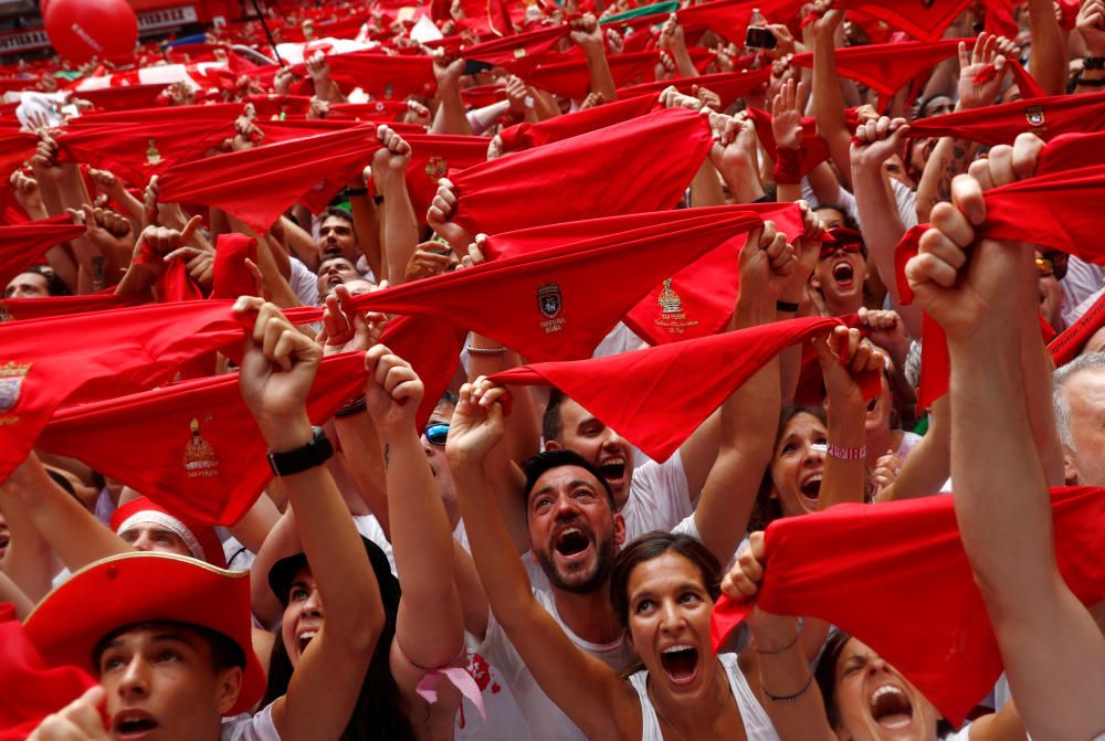 Miles de personas levantan pañuelos rojos durante el txupinazo que inicia los San Fermines.