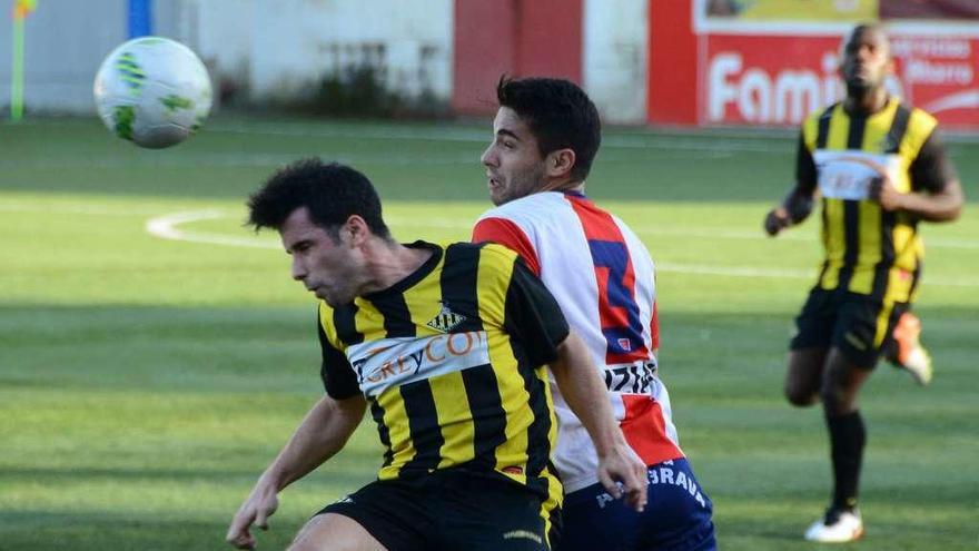 Hugo despeja un balón de cabeza ante la presión de Carminati durante un momento del partido disputado ayer en O Morrazo. // Gonzalo Núñez