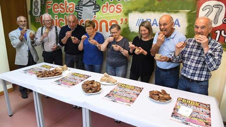 Vecinos de Feáns degustan chicharrones.