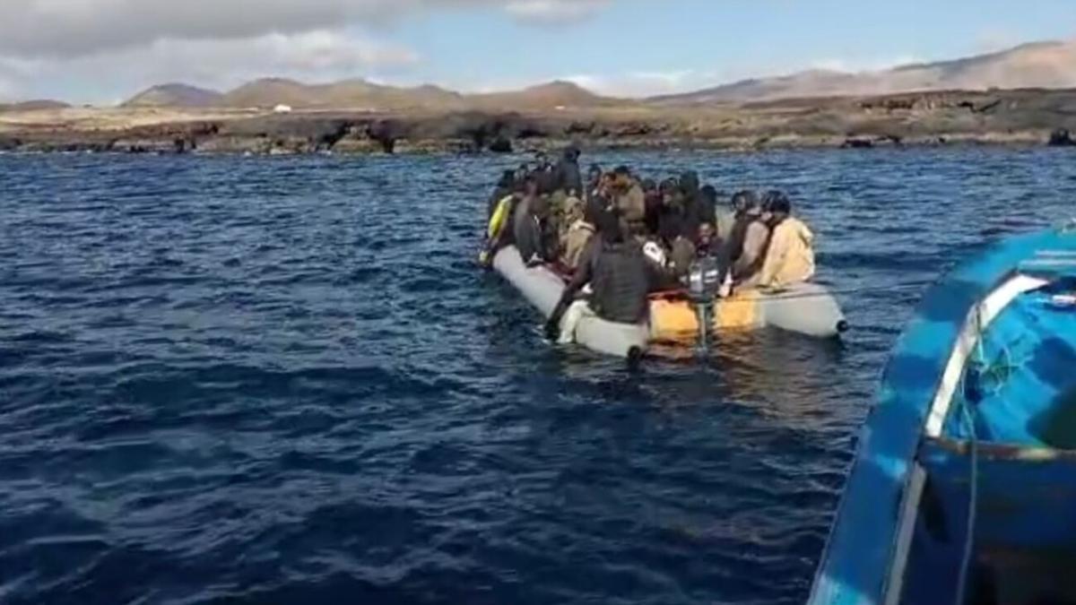 El pesquero lanzaroteño 'Mar Azul' auxilia a la neumática con una embarazada muerta y 52 migrantes frente a Los Cocoteros (Lanzarote) el pasado 20 de junio.