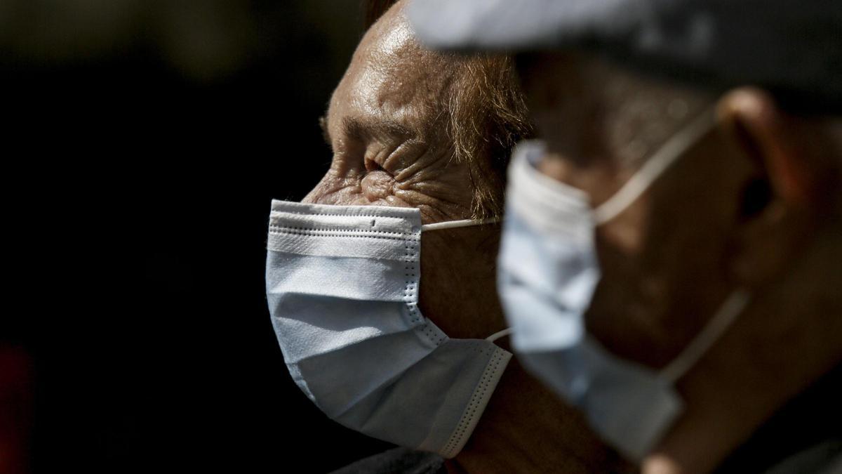 Ancianos con mascarilla por la calle.