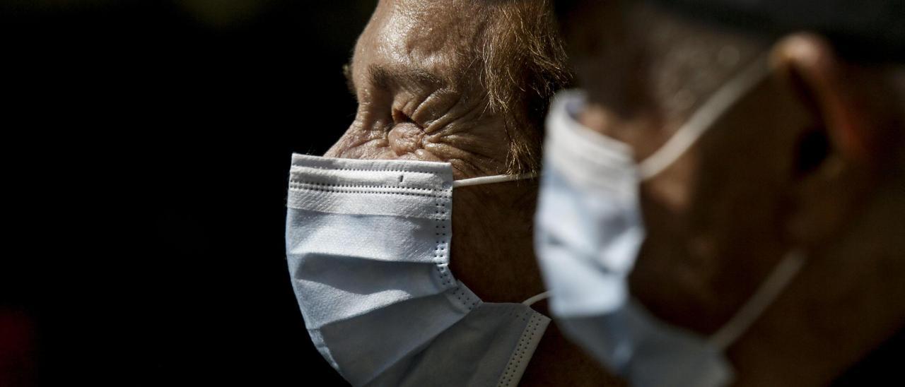 Ancianos con mascarilla por la calle.