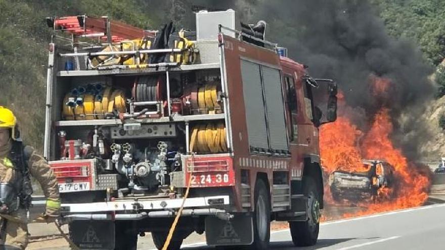El vehicle cremant i els Bombers actuant a l'Eix a Sant Hilari.