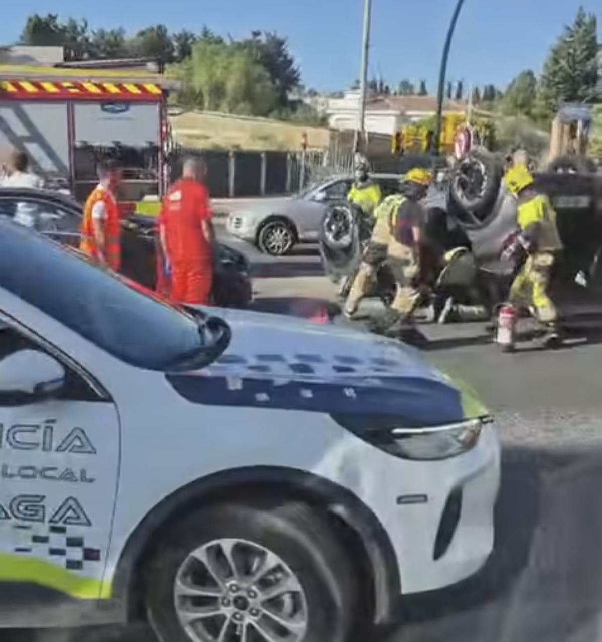 Los bomberos, durante la excarcelación de la persona atrapada en el coche volcado.