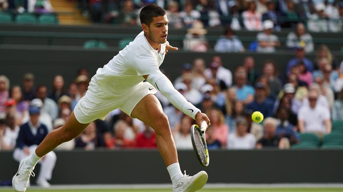 Carlos Alcaraz devuelve una bola en Wimbledon.