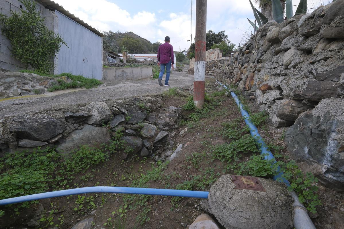 Benito Monagas, vecino del barrio, recorre una de las calles de Siete Puertas que carece de alcantarillado. Las tuberías azules son de abastecimiento de agua.