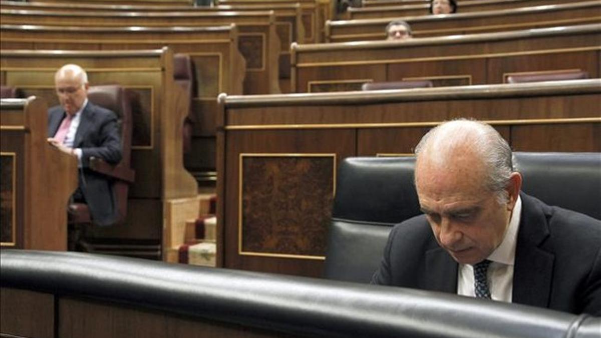 El ministro del Interior, Jorge Fernández Díaz, en primer plano, y, al fondo, el portavoz de CiU en el Congreso, Josep Antoni Duran Lleida, este 13 de marzo. EFE / J. J. GUILLÉN