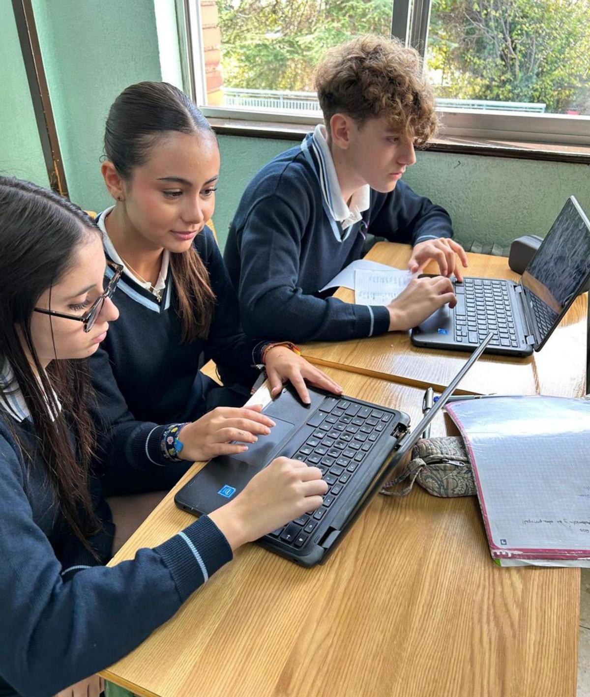 Trés estudiantes del centru trabayen nel proyeutu. |