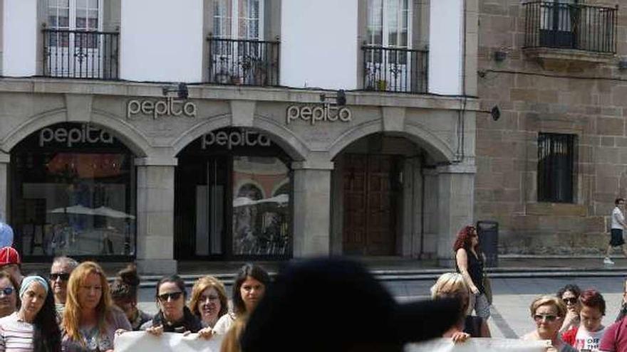 Un hombre cruza por delante de una pancarta alusiva a la violencia de género en una pasada concentración de repulsa en la plaza de España.