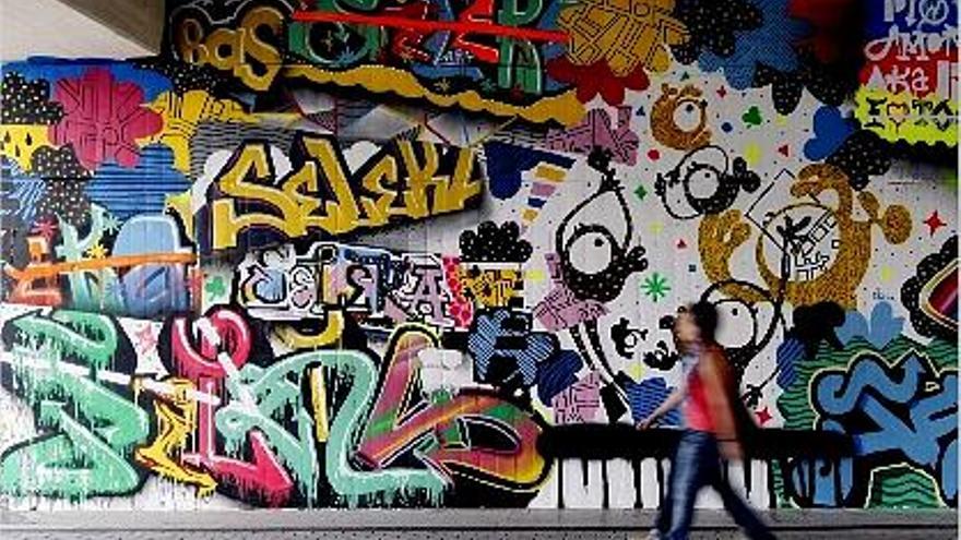 politécnica. Dos jóvenes estudiantes pasan por delante de un enorme grafiti.