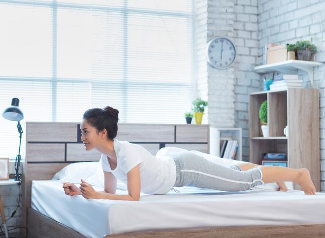 Plancha sobre antebrazos en la cama, deporte, actividad física