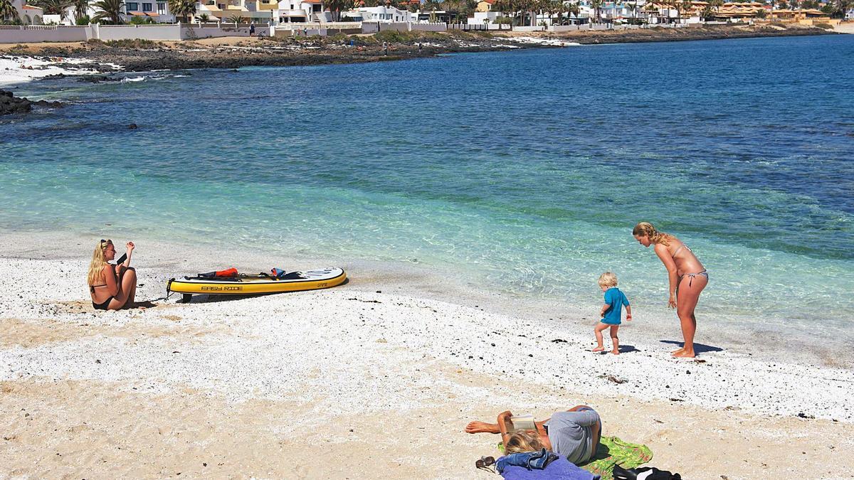 Una familia de turistas esta semana en la playa de Corralejo, en Fuerteventura. | | EFE