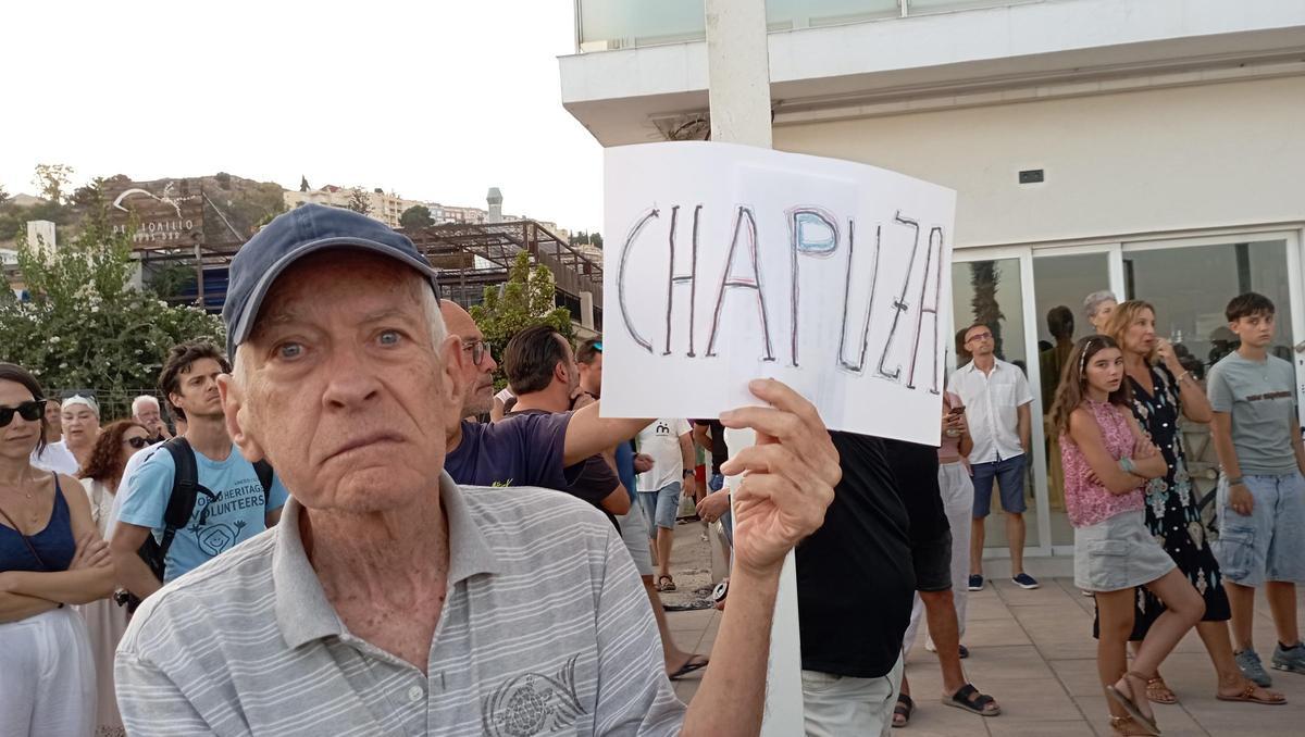 Un vecino de Pedregalejo, con un cartel de protesta por las obras del paseo marítimo, este domingo.