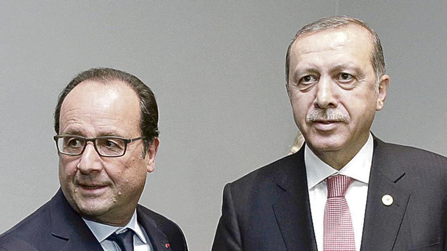 Los presidentes de Francia y Turquía se estrechan la mano en París.