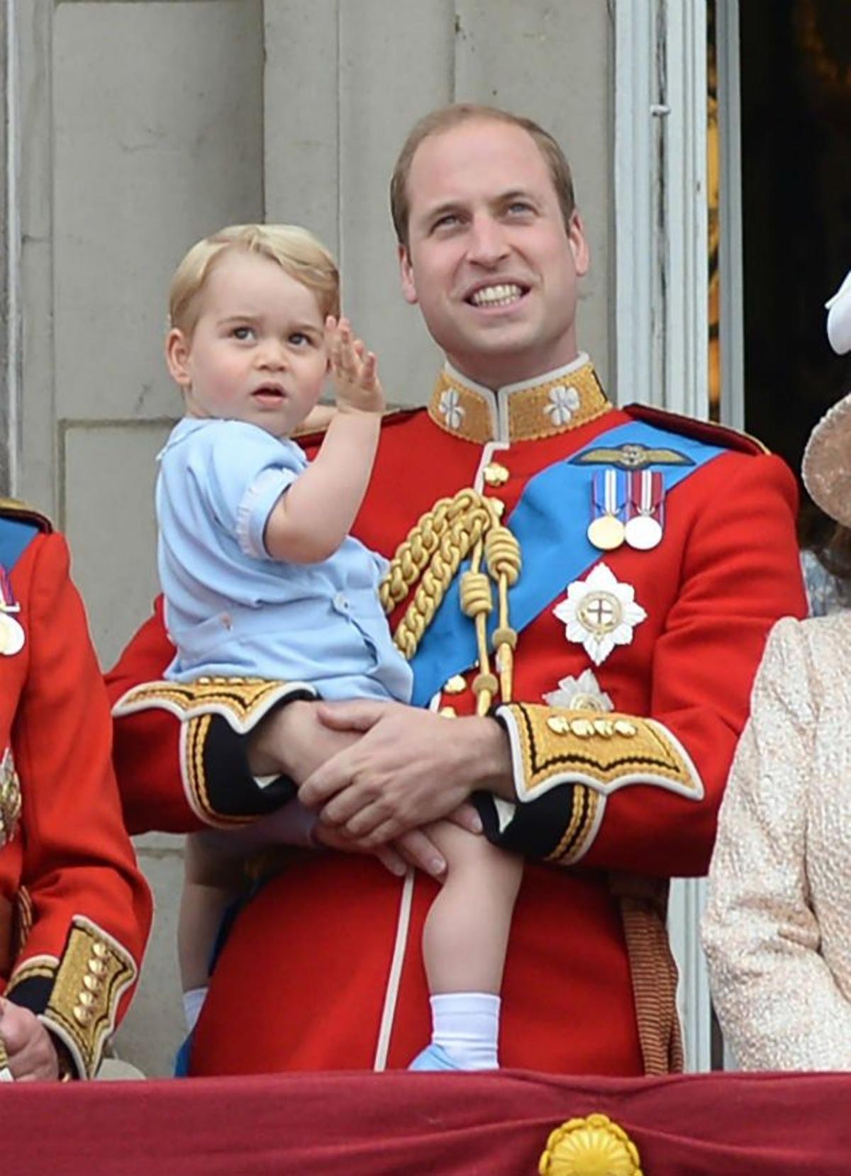 El príncipe George saluda con desgana con mono azul