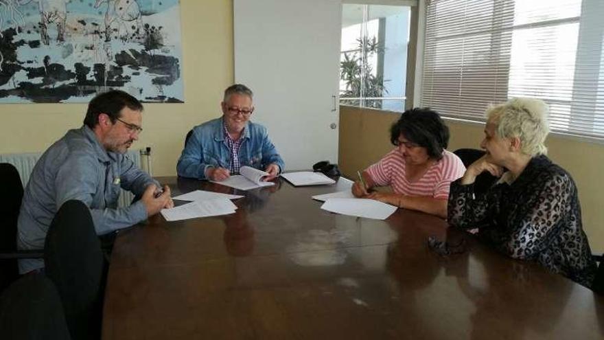 El alcalde (al frente) firma el convenio en el Concello. // FdV