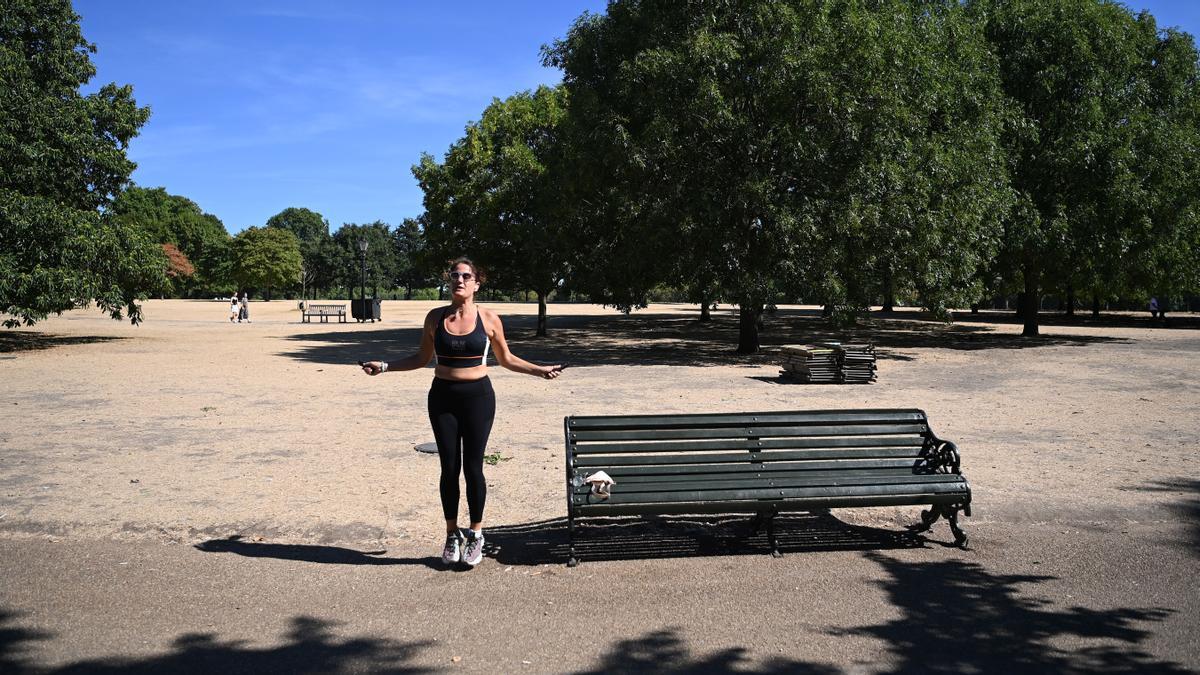 Una mujer hace ejercicio en un reseco Hyde Park en Londres