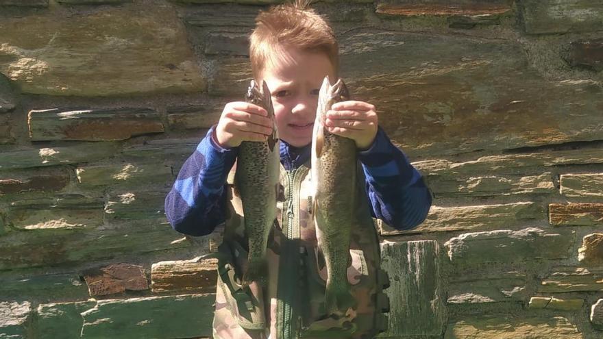 Un pequeño pescador sanabrés con dos truchas