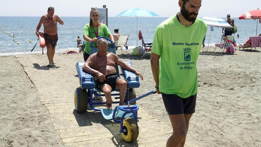 Voluntarios sacando del agua a una persona discapacitada.