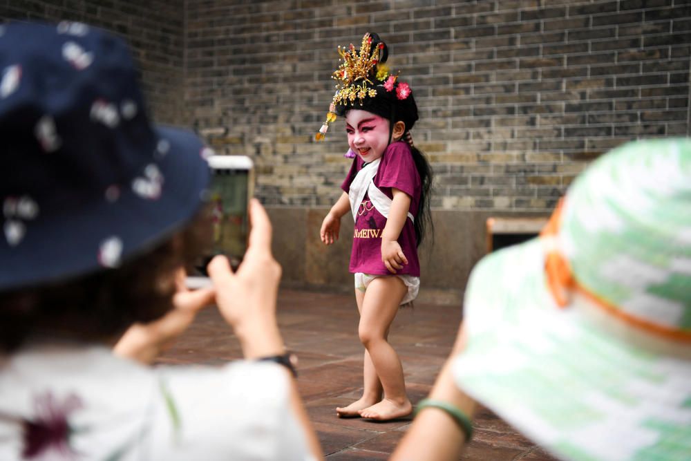 Visitors take photos of a child dressed in a ...