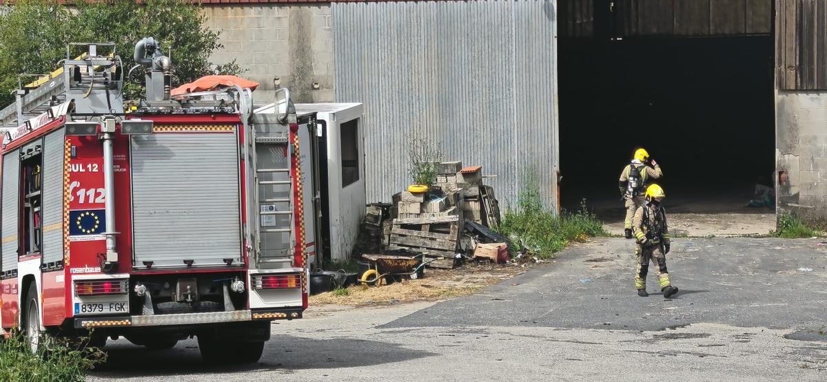 Efectivos de los Bombeiros do Morrazo en en recinto de la nave afectada por el fuego.