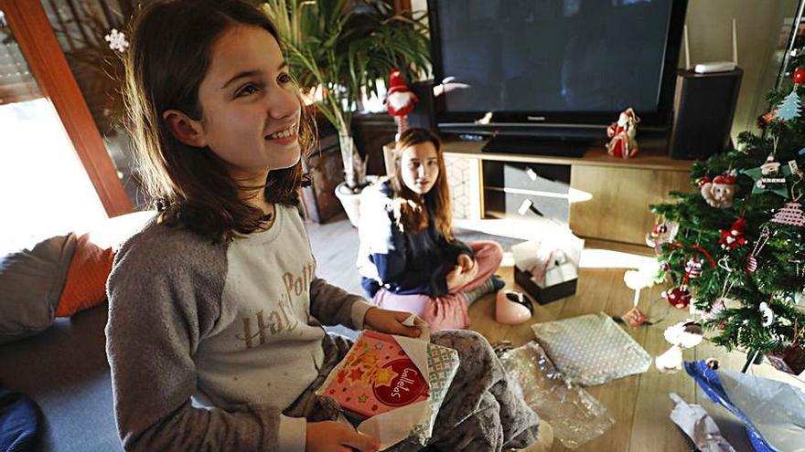 Vera y Candela Murias abren sus regalos de Reyes en su casa. | L. Murias