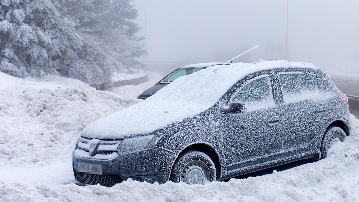 Un coche cubierto de nieve en la carretera de acceso al Puerto de Navacerrada (Madrid), el pasado día 19