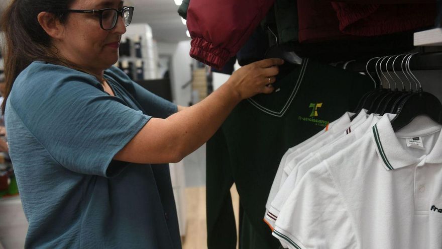 Iria Couto, de Dolco Uniformes, muestra dos prendas de diferentes colegios.   | // CARLOS PARDELLAS
