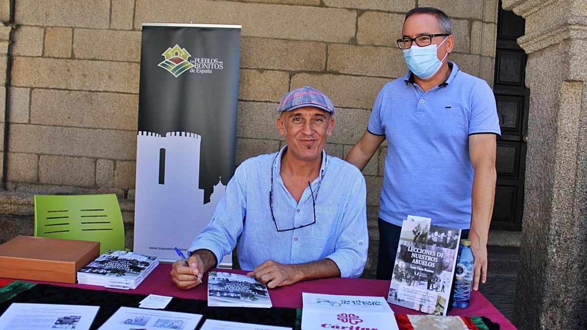 Luis Vivas, a la izquierda firmando libros, junto al teniente de alcalde de Puebla, Pedro Castronuño. | A. S.