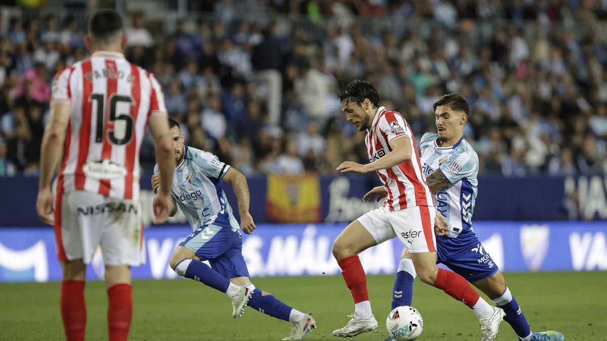 Un momento del partido entre el Sporting y el Málaga celebrando en el estadio de La Rosaleda.