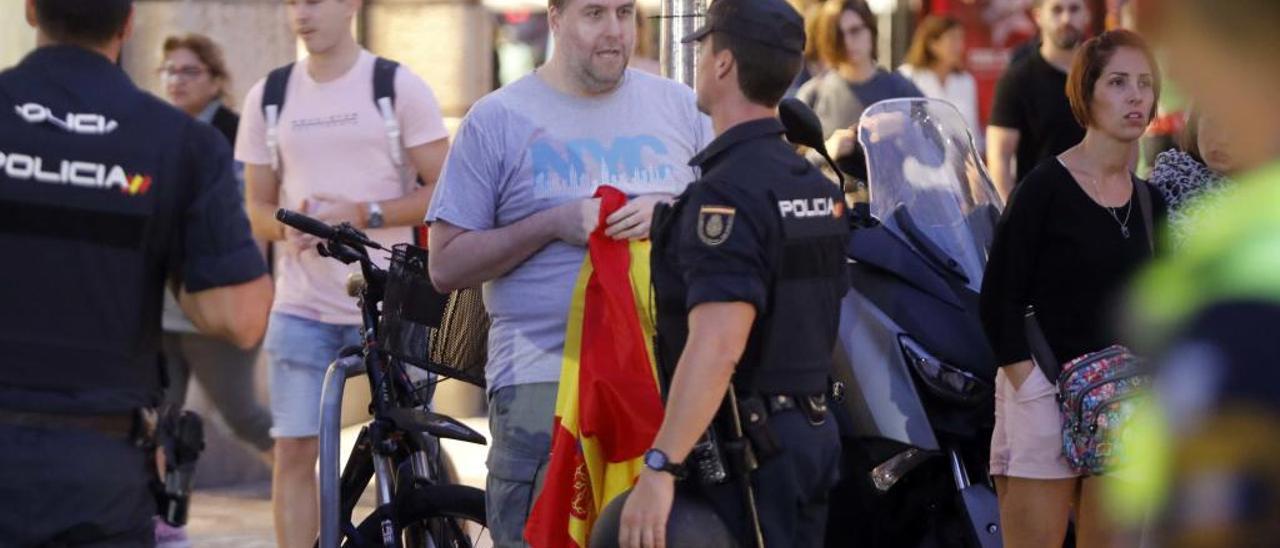 La Policía aleja a un contramanifestante con una bandera de España, ayer tarde.