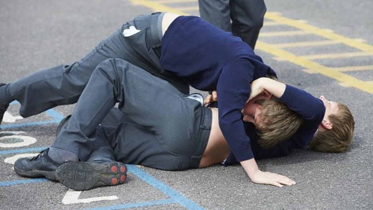 Dos menores se pelean en el suelo.