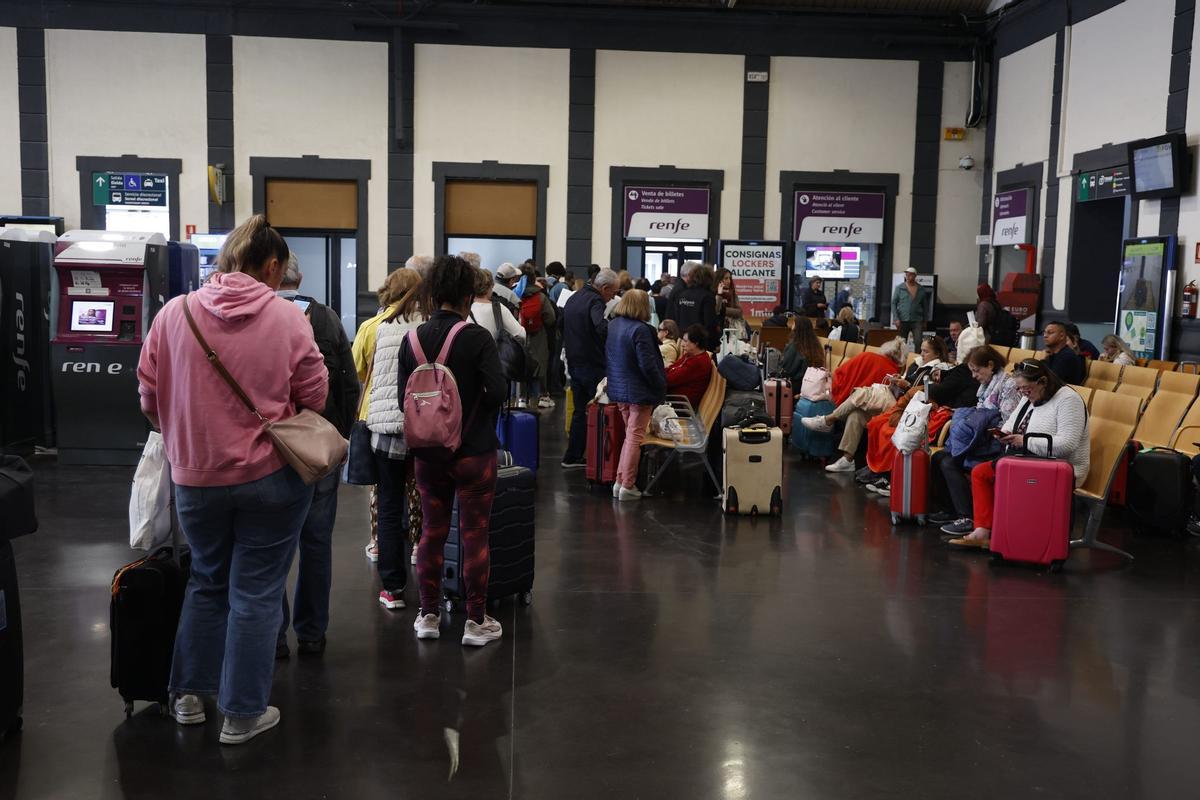 Pasajeros hacen cola en la estación de Alicante esta mañana para cambiar sus billetes.