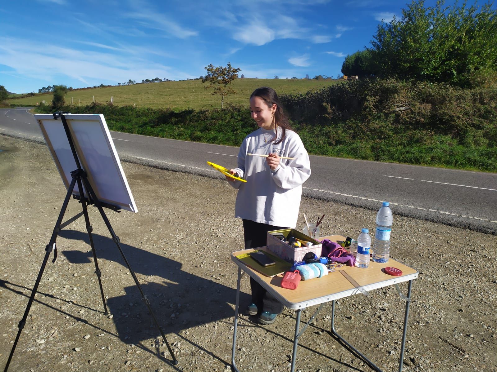 La ovetense Matilda Blanco, de 17 años, pintando un tractor junto a la carretera.