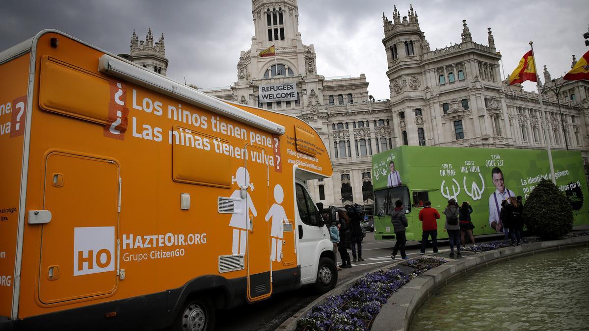 A la izquierda, la caravana de Hazte oír con el texto modificado. Al lado, el autobús de 'El intermedio'.