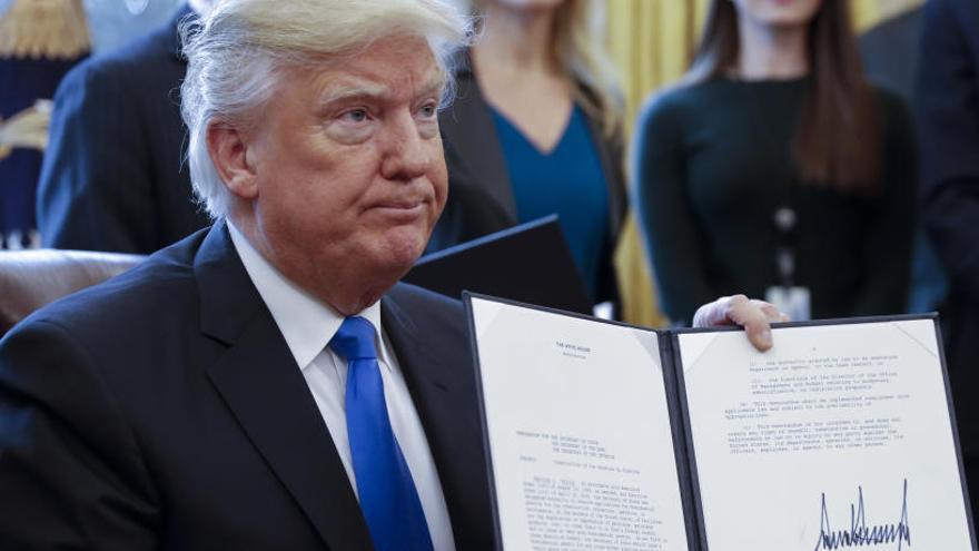 El president dels EUA Donald Trump amb un dels seus primers decrets signats.