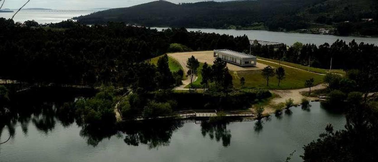 El centro de interpretación ubicado sobre la laguna de Pedras Miúdas, con la desembocadura del río Ulla, la ría de Arousa y el &quot;vía crucis&quot; fluvial, al fondo. // Iñaki Abella